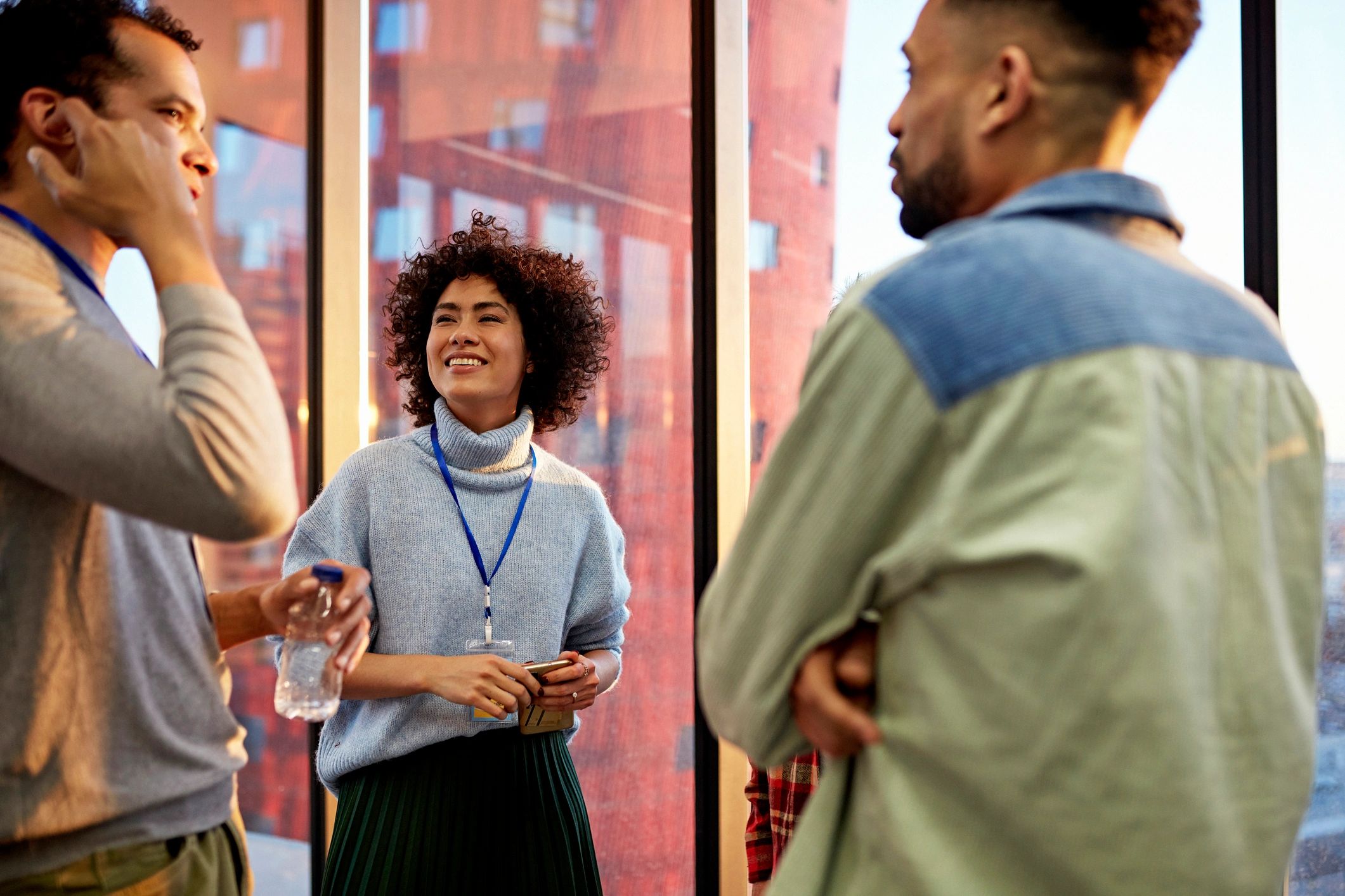 Guests chatting and smiling at an event in warm light