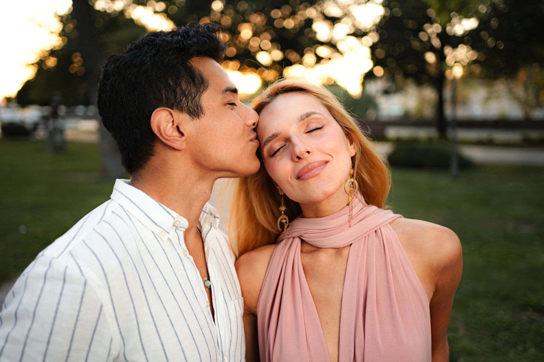 Couple sharing a tender moment at sunset in a park